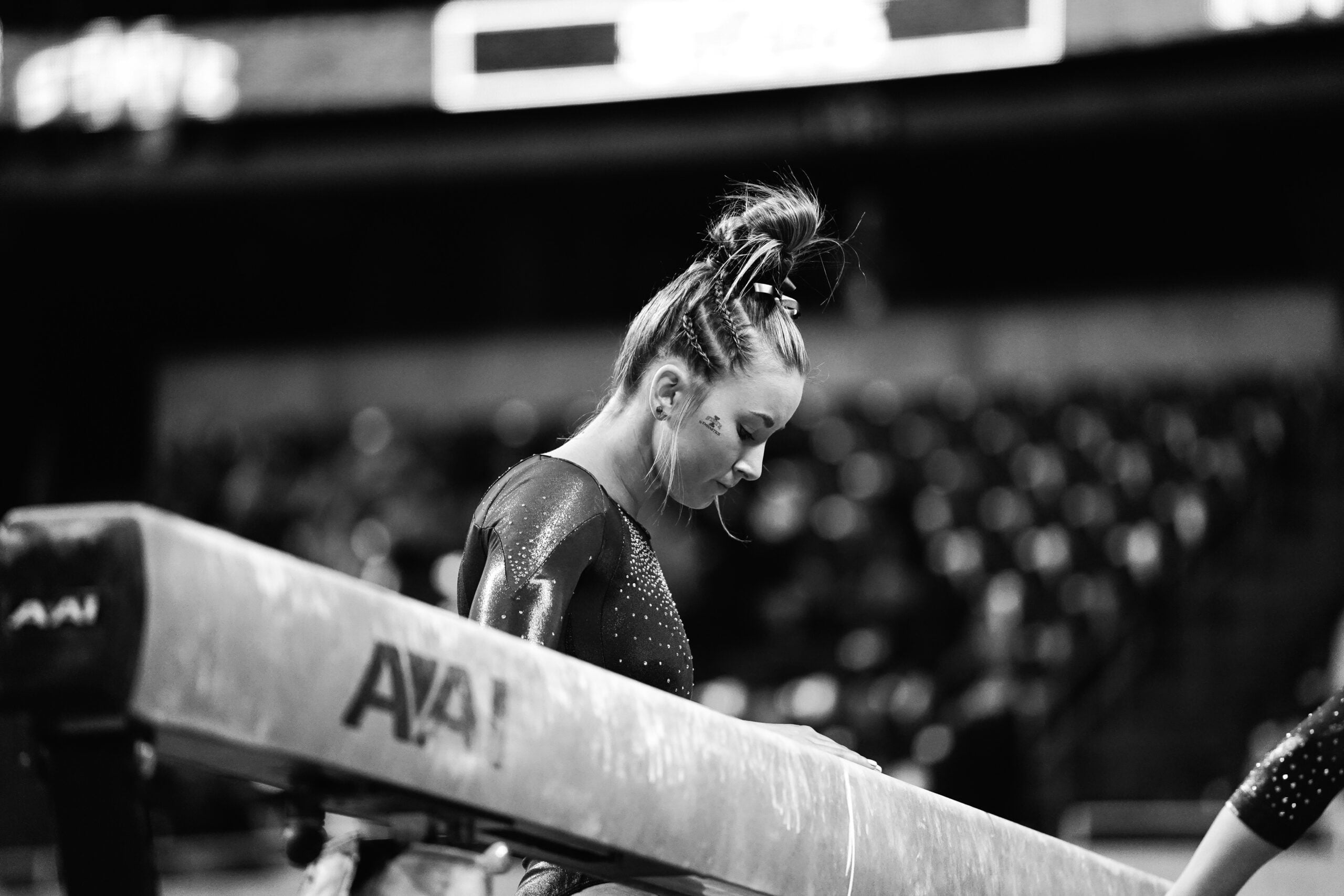 a woman sitting on a bench with a ponytail in her hair