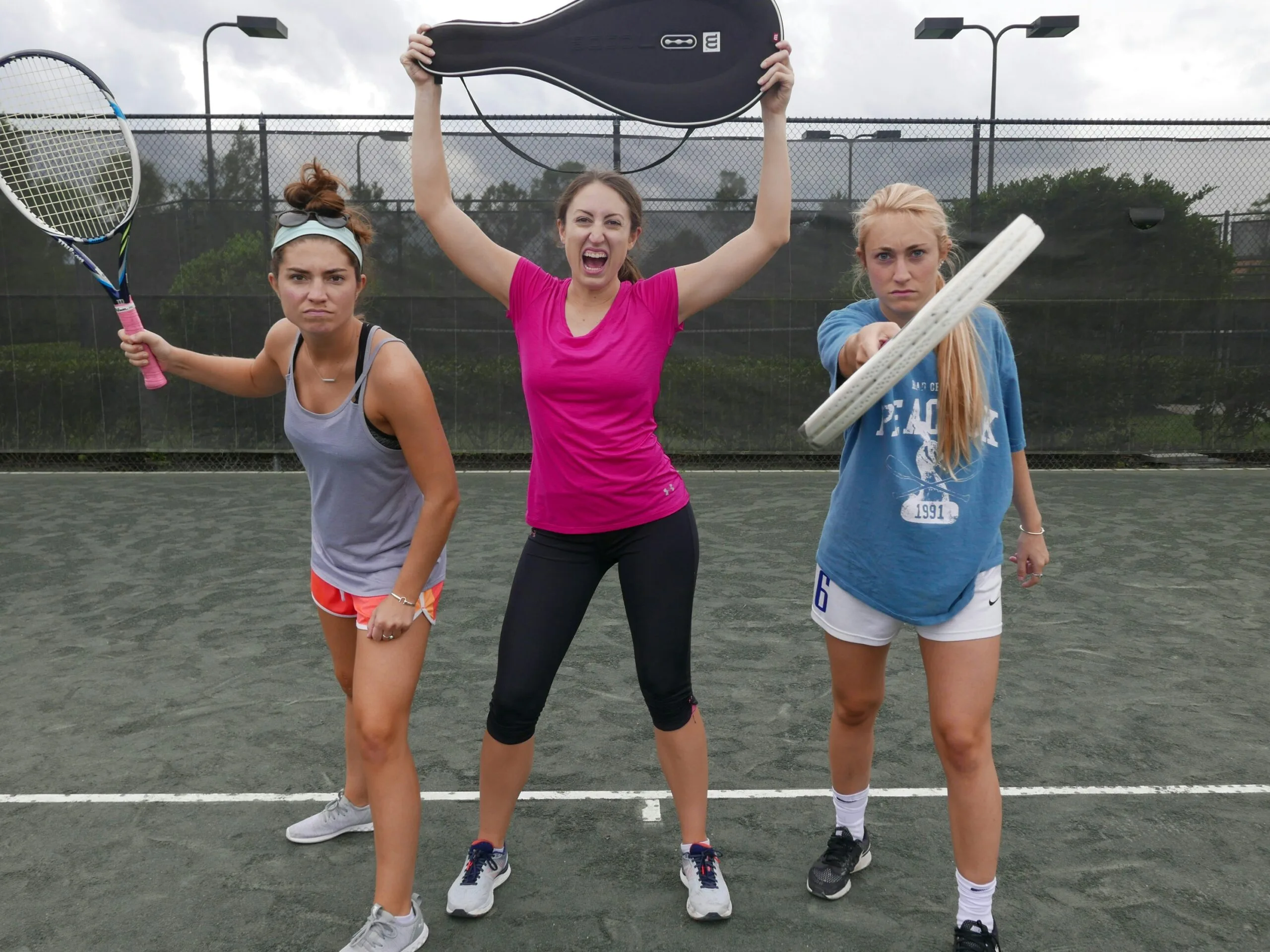 three women holding tennis rackets